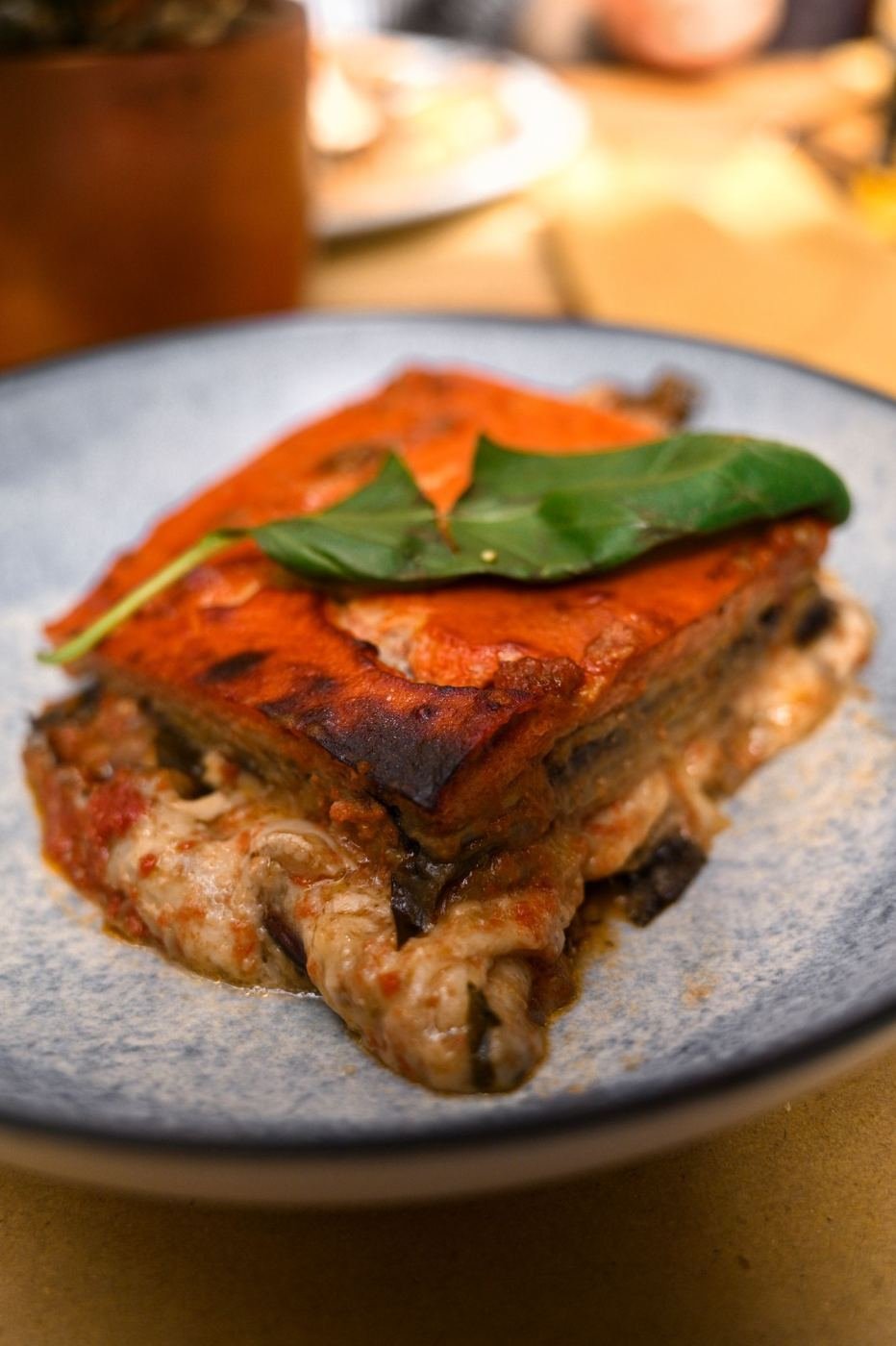 Fetta di parmigiana di melanzane siciliana con basilico
