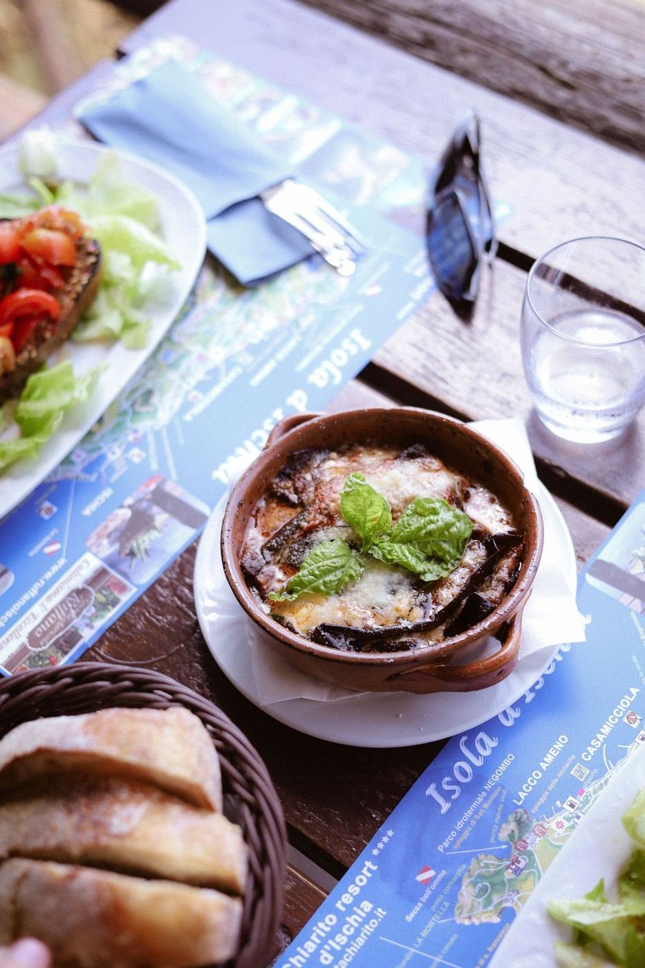 Teglia di parmigiana di melanzane su un tavolo rustico