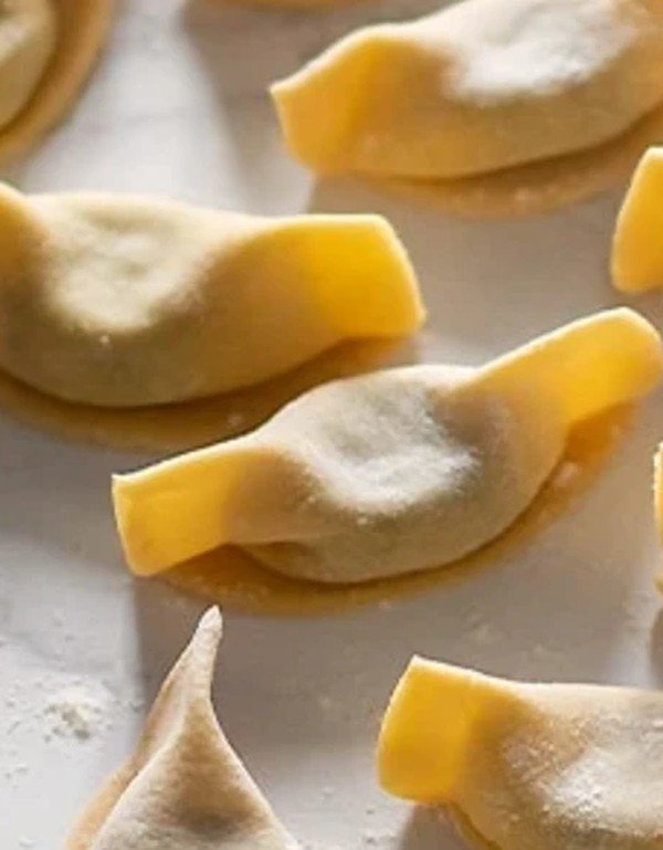 Casoncelli crudi a mezzaluna allineati sul piano di lavoro