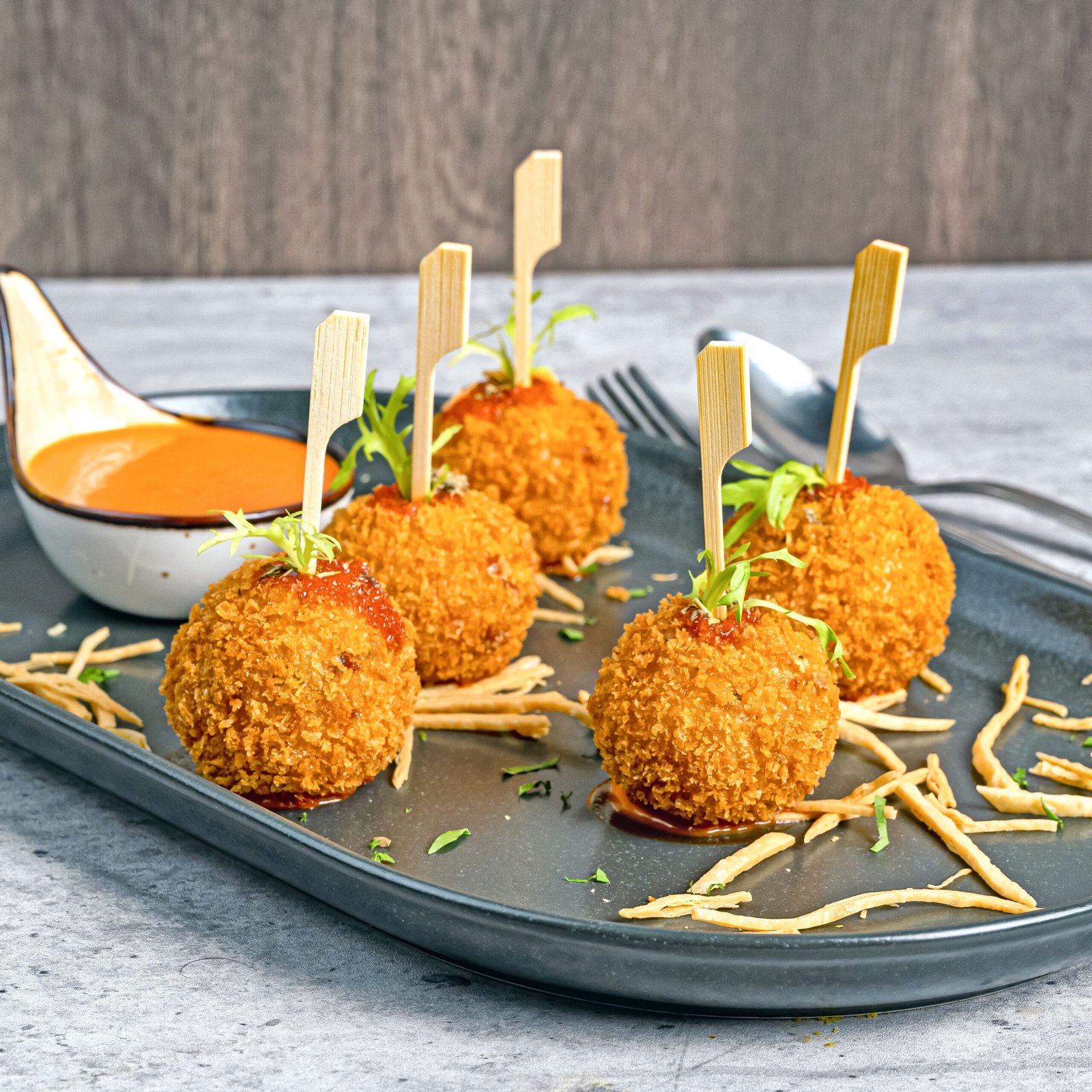 Cinque arancini dorati guarniti con erbe aromatiche