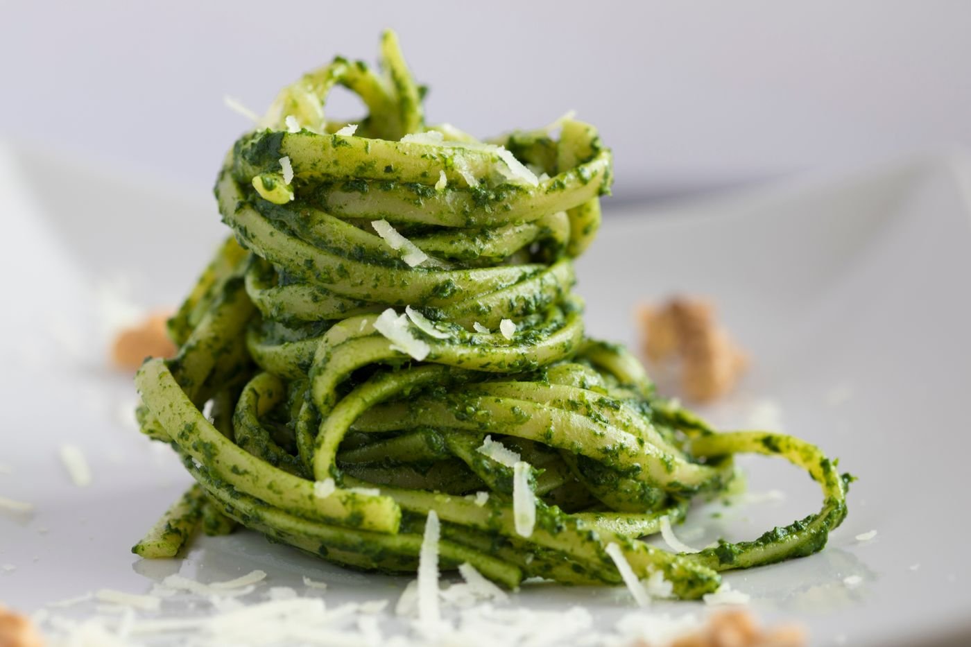Pasta lunga condita al pesto con formaggio grattugiato