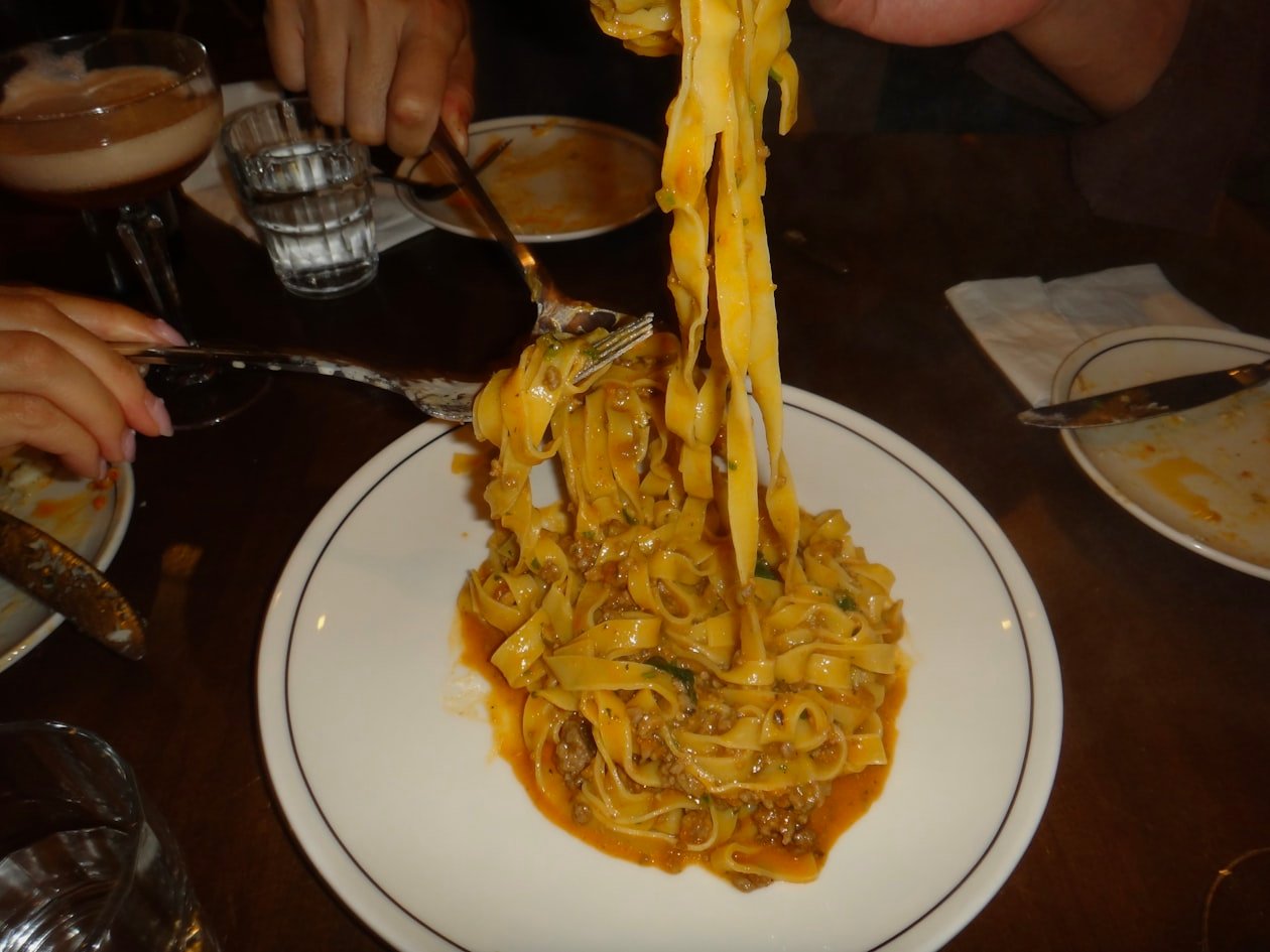 Forchettata di pasta al ragù sollevata dal piatto