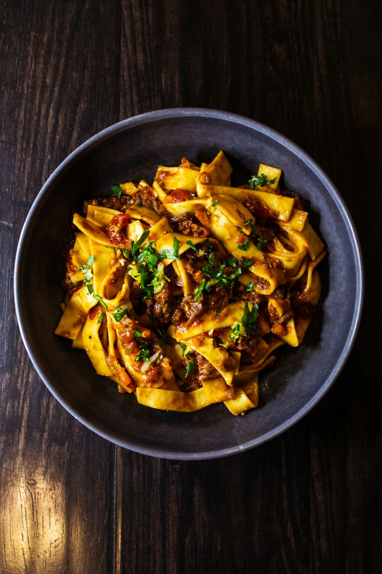 Pasta al ragù in ciotola di ceramica scura