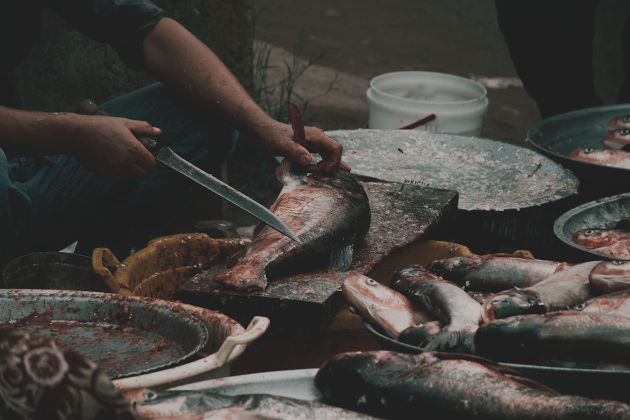 Pesce pulito al coltello sul banco di un mercato