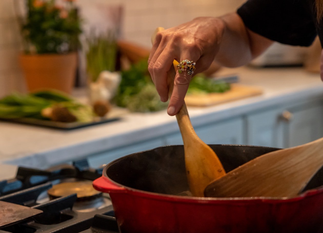Mani che mescolano il riso nella pentola per la panissa
