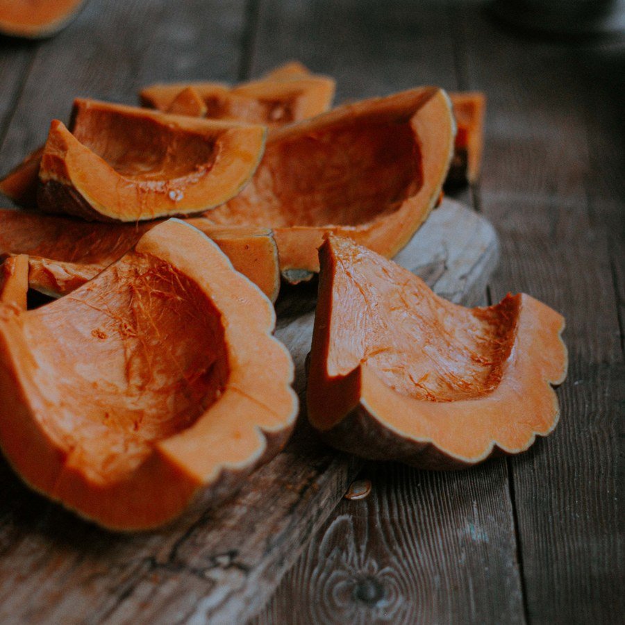 Spicchi di zucca svuotati su un tavolo di legno